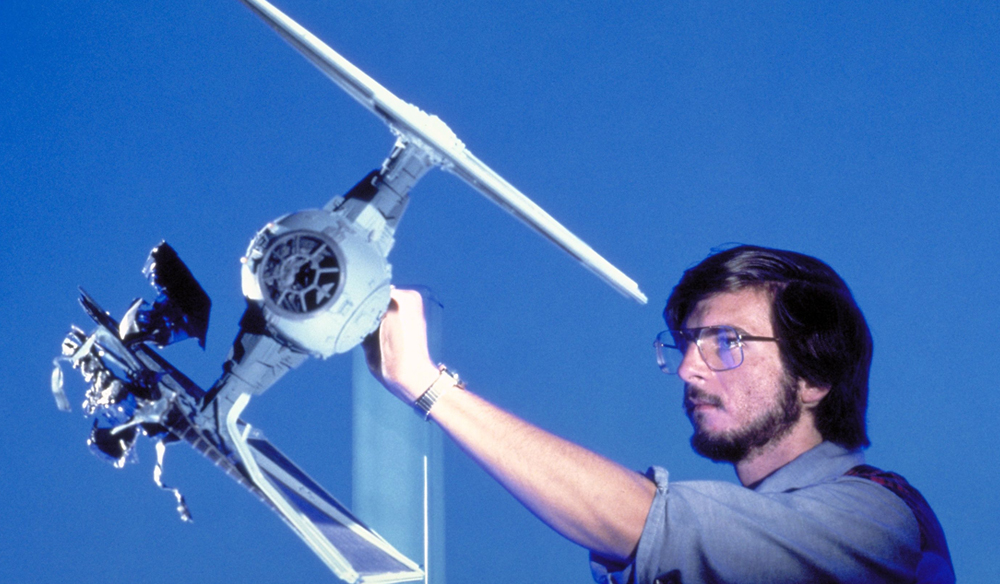 A miniature Tie Fighter shot against a blue screen.